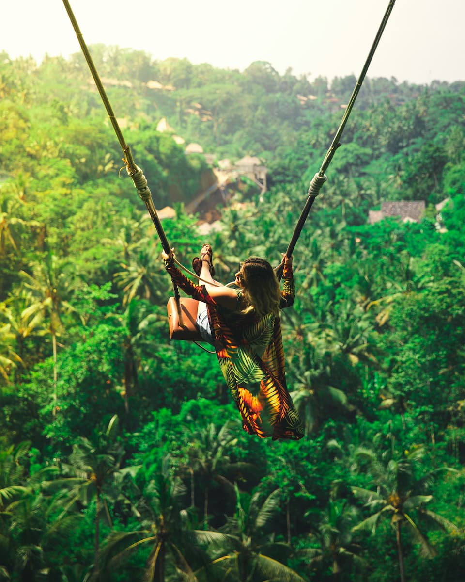 Woman on a jungle swing overlooking the Ubud valley, Bali