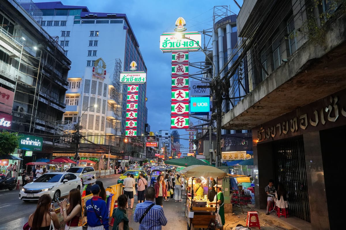 Gold shop neon signage and street food stalls lit up at night on Yaowarat Road in Bangkok's Chinatown