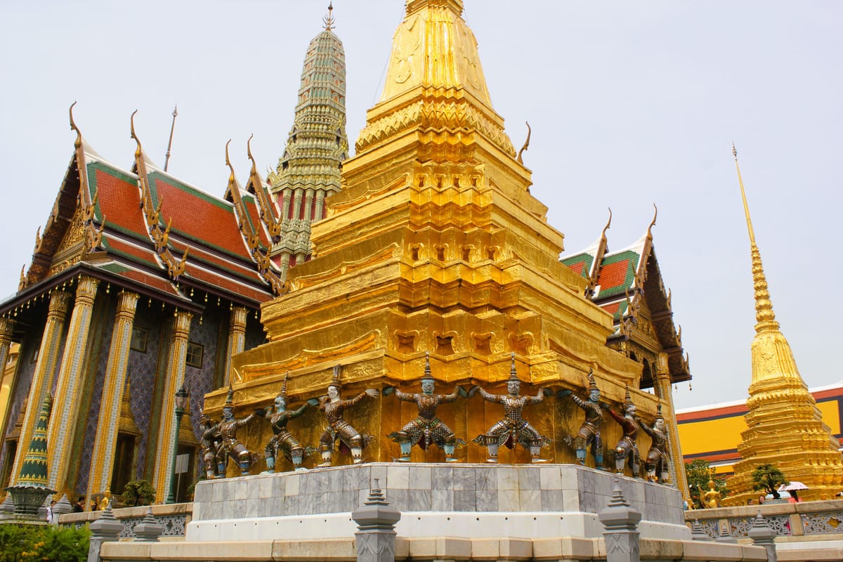 The golden chedi and guardian statues of the Grand Palace complex in Bangkok, Thailand