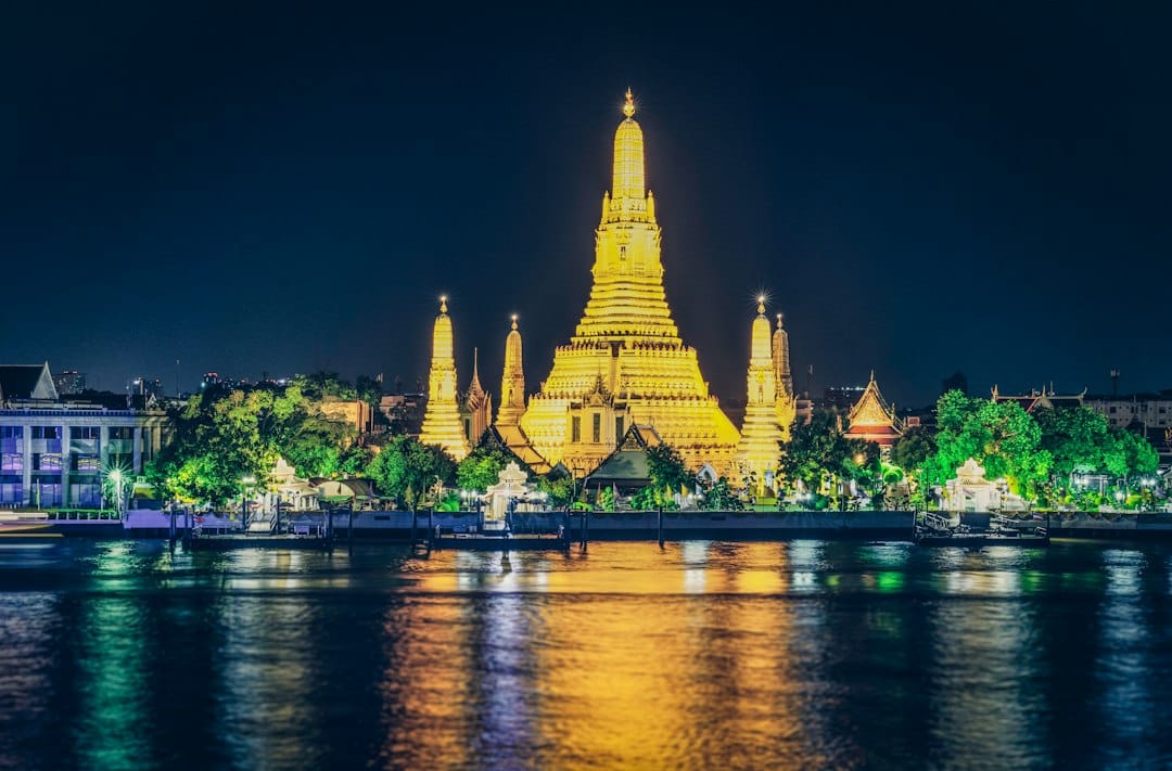 Wat Arun, the Temple of Dawn, illuminated at dusk on the bank of the Chao Phraya River in Bangkok. Photo by Tuan Nguyen on Unsplash
