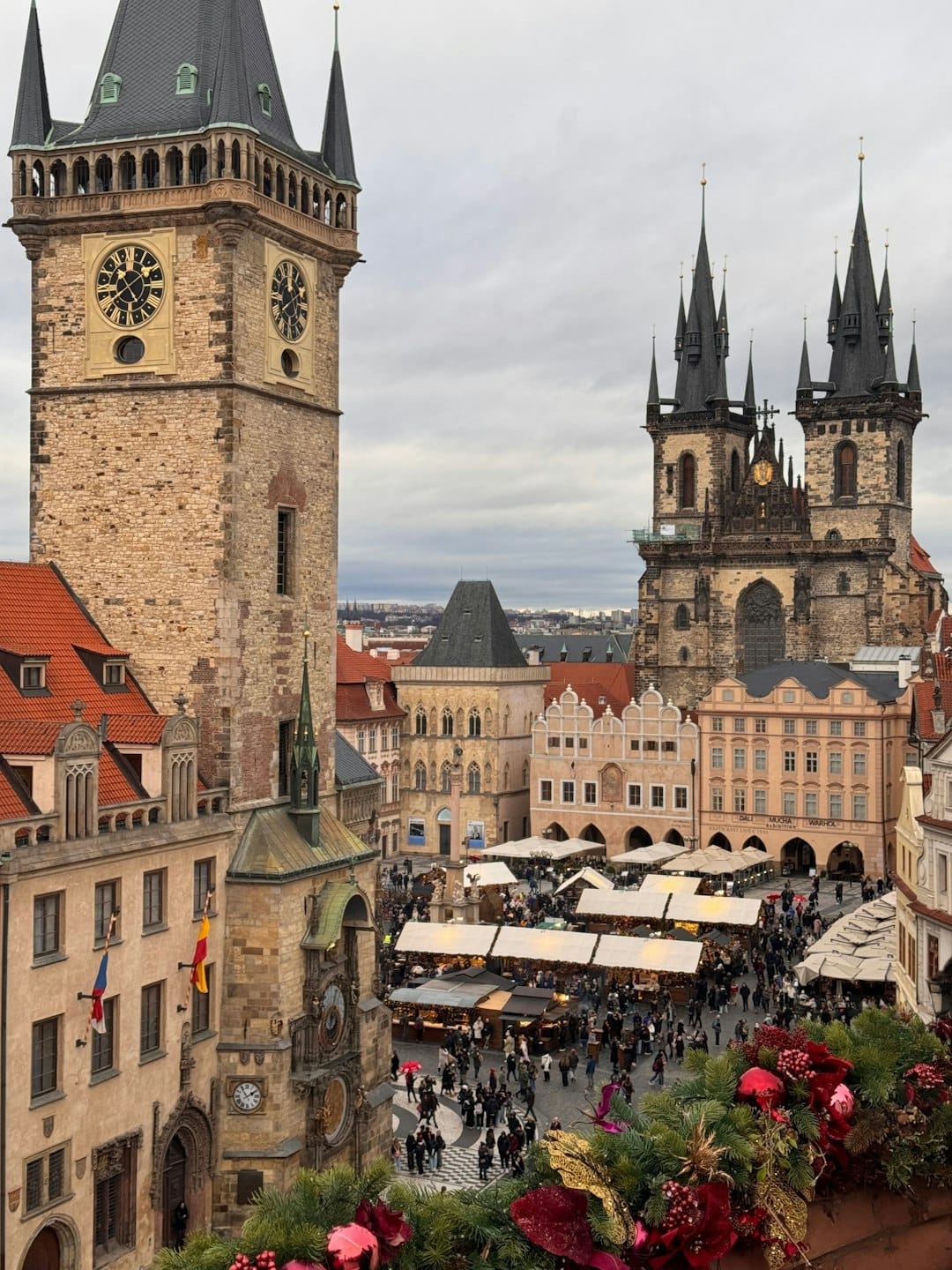 Aerial view of Prague's Old Town Square Christmas market with the Astronomical Clock tower and Týn Church spires. Photo by Ahmadreza Zibaei on Unsplash