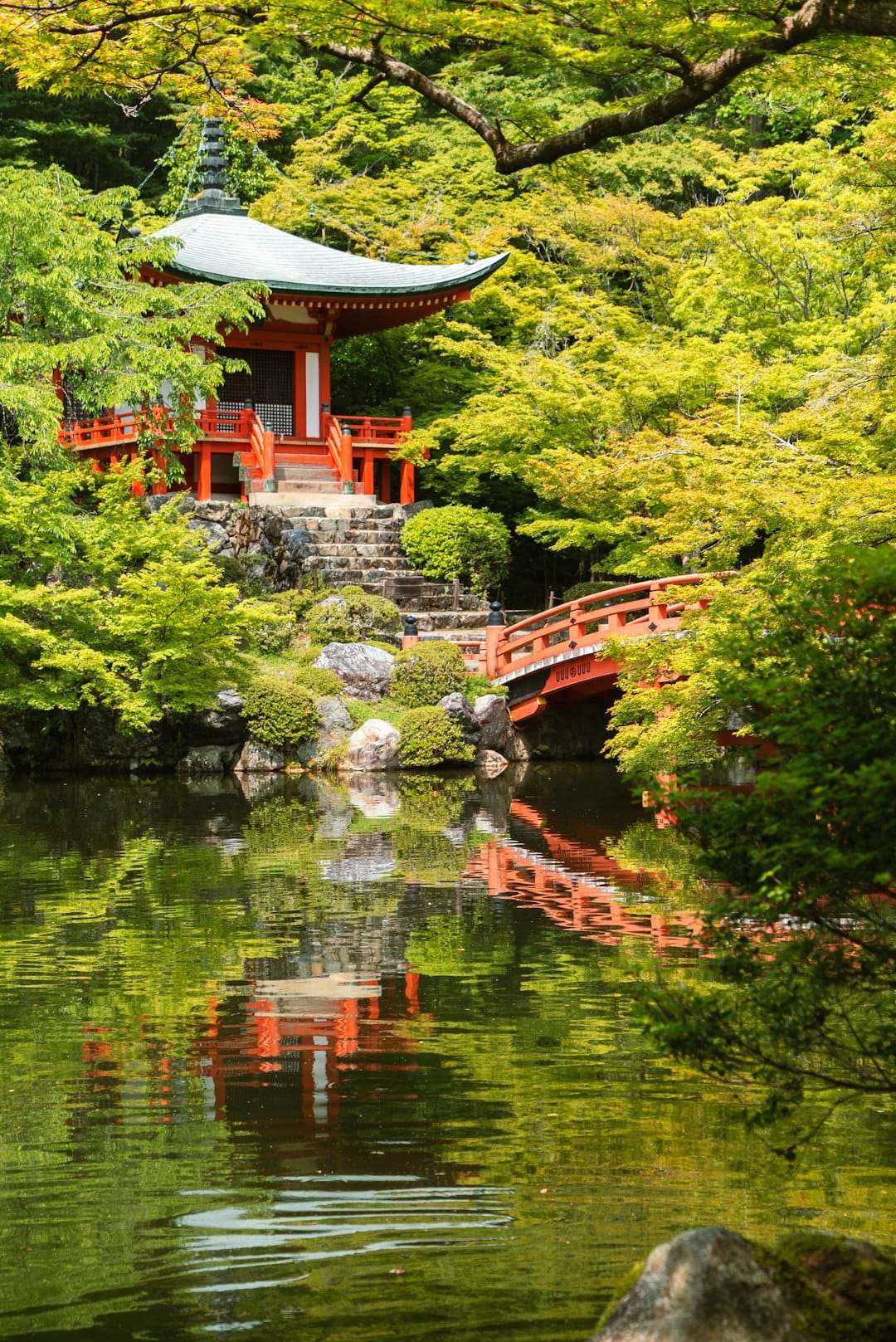 A red temple building reflected in a still pond surrounded by autumn foliage, Kyoto, Japan. Photo by David Emrich on Unsplash
