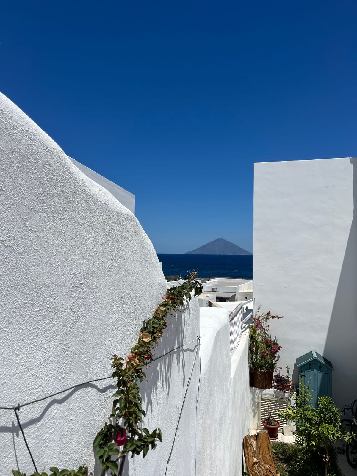 Whitewashed building with Stromboli's volcanic cone visible across the sea, Aeolian Islands, Sicily